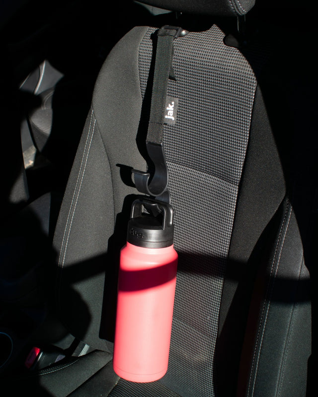Dug Jak car headrest bottle holder securing 1.1L Dug bottle on passenger seat